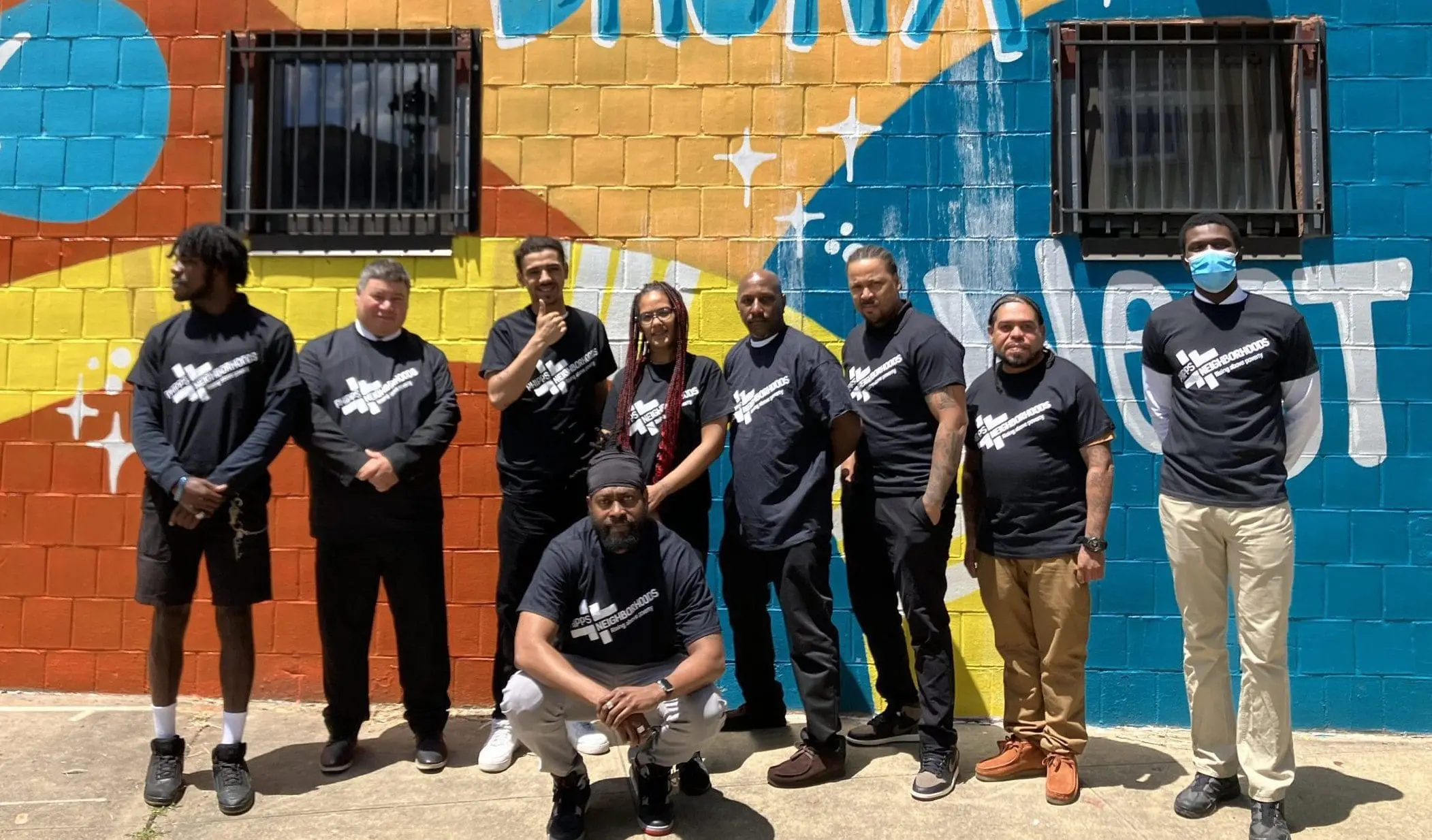 Group of Career Network program participants in front of a colorful mural